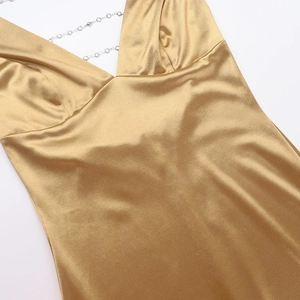 Close-up of champagne satin V-neck dress with sparkling rhinestone chain straps