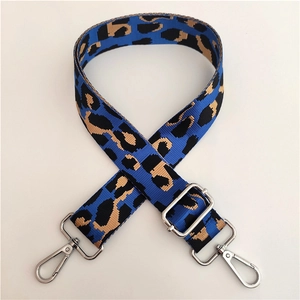 Macro view of blue leopard pattern wide shoulder strap with silver metal swivel hooks