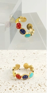 Macro detail of gold-plated stainless steel ring with colorful enamel smile faces