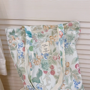 Close-up of vintage fruit pattern and stitched label on cotton canvas tote bag