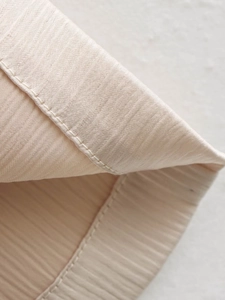 Détail macro du tissu côtelé champagne avec ourlet à double couture de haute qualité et éclat