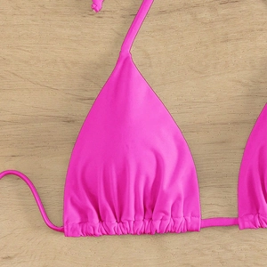 Detail of rose pink triangle bikini top featuring ruching and adjustable tie strings