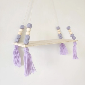 Detail of Nordic wooden hanging shelf featuring purple and natural octagonal beads with tassels