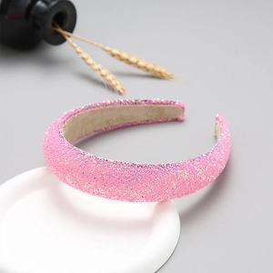 Detail of pink glitter headband on a minimalist display stand for fashion styling