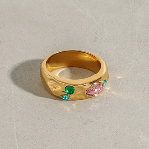 Detail of gold hammer textured ring with pink, green and blue zircon gemstones