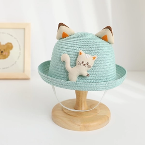 Detail of light blue straw sun hat for children with 3D cat ears and elastic chin strap