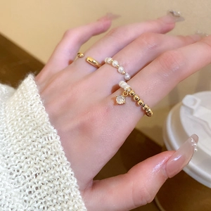 3-piece gold plated ring set with pearls and zircon pendant worn on a model's finger