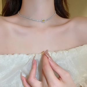 Close-up of elegant French style choker with yellow square zircon and tennis chain details