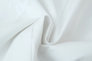 Macro shot of white woven fabric detail showing smooth texture and high-density fiber
