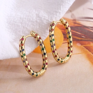 Pendientes de aro ovalados bañados en oro con circonitas de colores sobre base texturizada