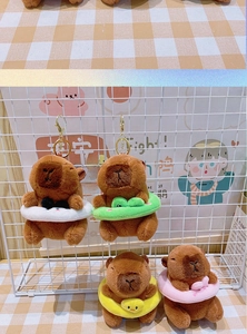 Close-up of plush capybara keychains with panda, frog, duck, and bow swimming rings