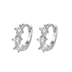 Close-up of silver hoop earrings with three inlaid sparkling zirconias on white background