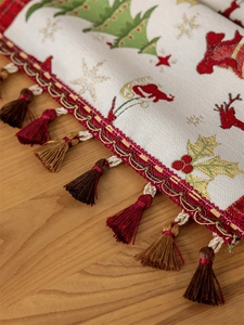Detail of Christmas table runner with jacquard reindeer patterns and festive fringe