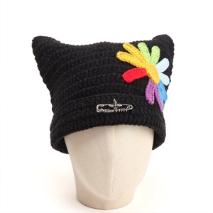 Detail of black crochet cat ear beanie with rainbow flowers and silver pin decoration