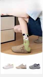 Detail of light green cotton socks with cartoon dog pattern shown with lifestyle footwear