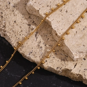 Detailed macro view of 18K gold-plated stainless steel chain necklace with small beads