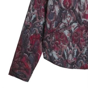 Detail of quilted seamwork and vibrant tie-dye pattern on a women's suede jacket