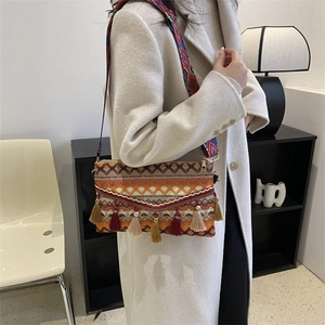 Close-up of Bohemian crossbody bag with colorful tassels and ethnic woven wide strap