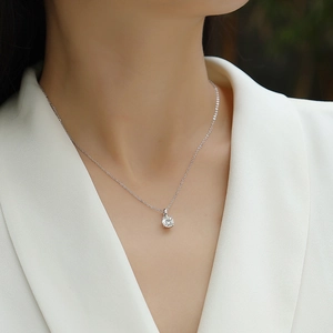 Close-up of a minimalist S925 sterling silver necklace with a square moissanite pendant