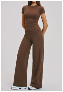Detail of high-waisted wide-leg yoga pants and slim-fit top in dark brown matte fabric