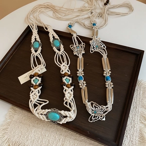 Detail of bohemian woven waist chains with turquoise beads and silver butterfly charms