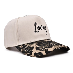 Close-up of Lovey embroidery and leopard print brim on a cream five-panel cap