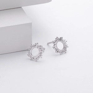 Detailed view of S925 sterling silver sunburst stud earrings on white geometric blocks