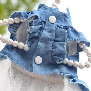 Close-up of light blue denim pet dress with lace tulle hem on a pearl hanger