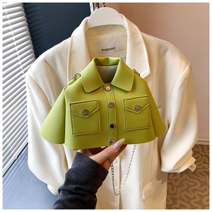 Detail of creative green coat-shaped crossbody bag with gold buttons and metal chain strap
