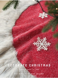 Detailed view of red felt Christmas tree skirt with plush white faux fur trim and snowflakes