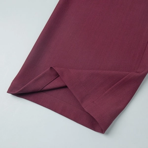 Macro view of deep burgundy twill trousers showing high-quality stitching and fabric texture