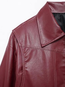 Detail of dark wine red leather jacket showing fine stitching and collar texture