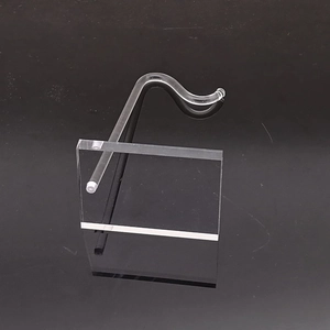 Close-up of a clear acrylic jewelry display stand with a square base and S-hook design
