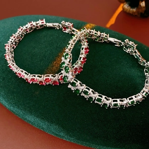 Nahaufnahme der Silberarmbänder mit roten und grünen Zirkonsteinen auf Samtständer
