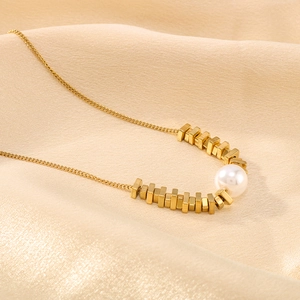 Irregular square pendant necklace with pearl on gold silk fabric background