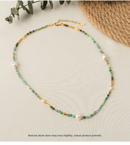 Macro detail of natural stone beaded necklace with freshwater pearls and golden clasp