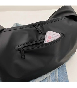 Détail d'une poche zippée arrière fonctionnelle sur un sac de sport noir en nylon