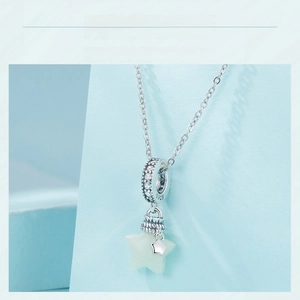 Close-up of S925 silver star pendant with luminous stone and sparkling pavé details