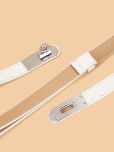 Macro shot of white crossgrain leather belt with silver swivel lock buckle detail