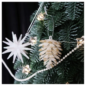 Champagne glitter pine cone and star ornaments hanging on a green Christmas tree