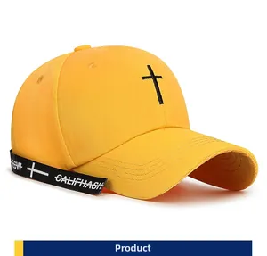 Detail view of bright yellow baseball cap featuring black cross embroidery and long ribbons