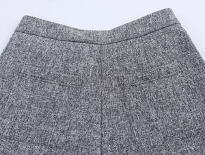 Detail of grey tweed trousers showing the back waistband, darts, and welt pockets