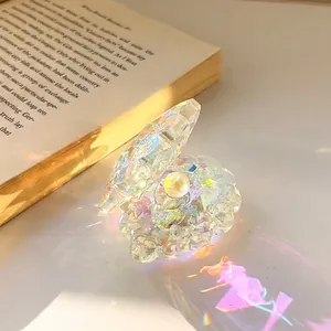 Rainbow AB crystal seashell ornament with pearl on an open book background