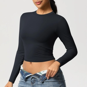 Détail d'un crop top de sport noir à manches longues avec tissu respirant et col rond
