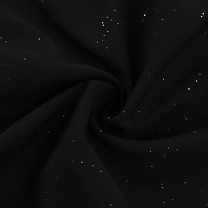 Vista macro de tela negra con purpurina plateada y detalles elegantes de textura fruncida