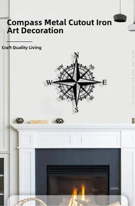 Macro shot of black iron compass wall decor hanging above a white indoor fireplace