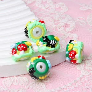 Detailed view of hand-painted acrylic beads with ant and mushroom patterns for DIY crafts