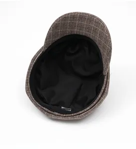 Detail view of the black fabric lining and neat stitching inside the plaid newsboy cap