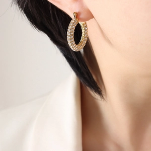 Elegant gold U-shaped hoop earrings with pave cubic zirconia worn by a model