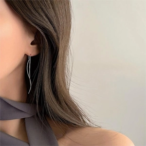 Close-up of minimalist S925 sterling silver long wavy threader earrings on model